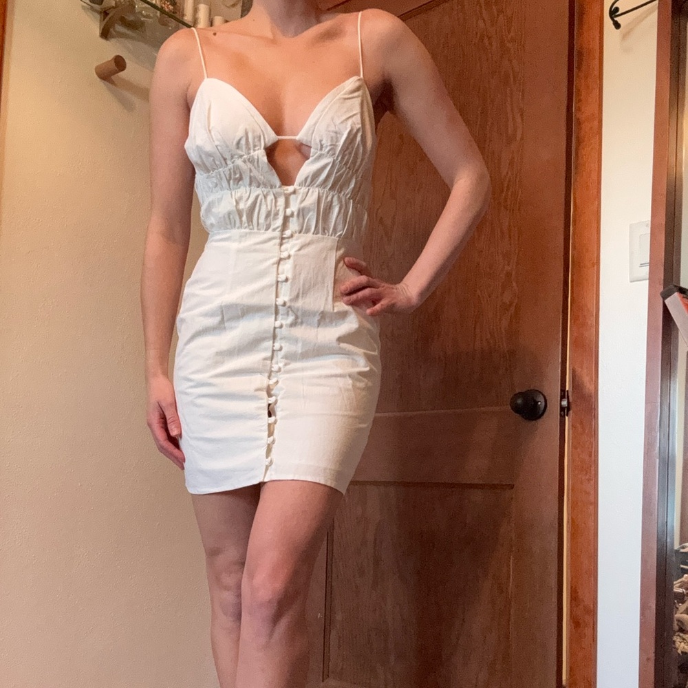White cotton mini dress with fabric button details and invisible back zipper